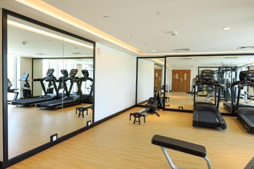 - une salle de sport avec tapis de course, vélos elliptiques et miroirs dans l'établissement 2 Bedrooms in Al Reem Island Near Cleveland Clinic, à Abu Dhabi