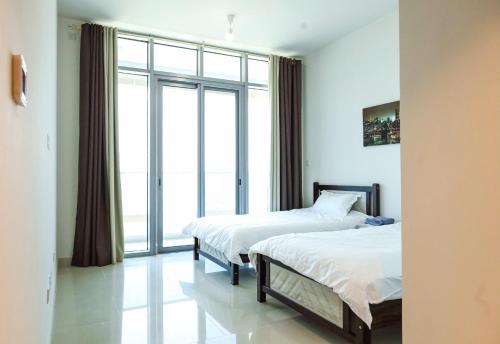 a bedroom with two beds and a large window at 2 Bedrooms in Al Reem Island Near Cleveland Clinic in Abu Dhabi