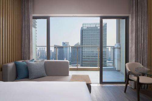 um quarto de hotel com uma cama e uma grande janela em Courtyard by Marriott Foshan em Foshan