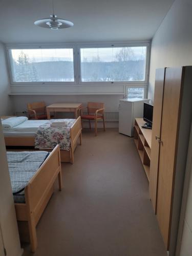 a dorm room with two beds and a table and chairs at Särkkä in Äänekoski
