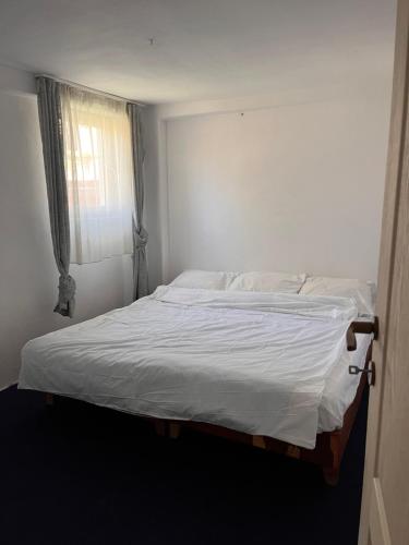 uma cama branca num quarto com uma janela em Greta’s Home 