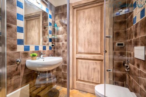 a bathroom with a sink and a toilet and a shower at Villa Girasoli con piscina privata e SPA a 2km dalla spiaggia in Alghero