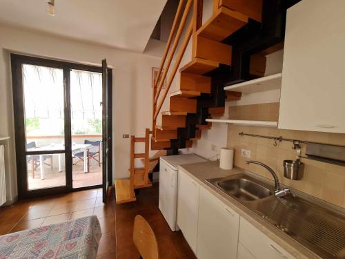 uma cozinha com um lavatório e uma escada com uma mesa em R13 Bilocale a 200 mt dal mare em Numana