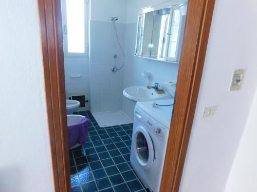 y baño con lavadora y lavamanos. en Appartamento San Carlo, Condofuri (RC), en Condofuri Marina