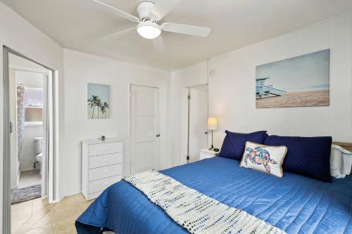 a bedroom with a blue bed and a ceiling fan at 210 Forty Fourth Street in Newport Beach