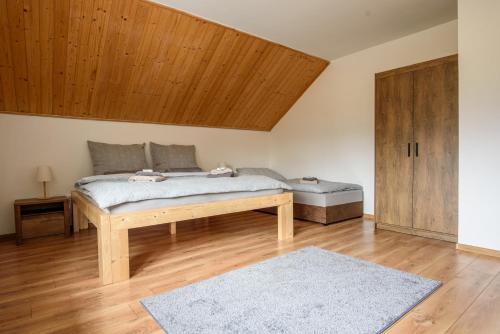 1 dormitorio con cama y techo de madera en Superior Apartmán, en Horní Radechová