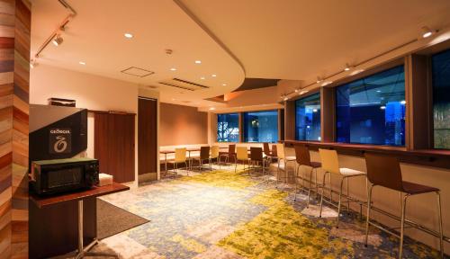 a conference room with chairs and a tv and windows at Hotel New Gaea Domemae in Fukuoka