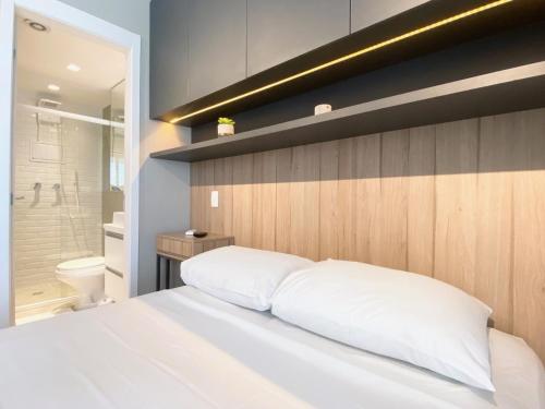 a bedroom with a white bed and a shower at Flat WiseSP - Expo Anhembi in Sao Paulo