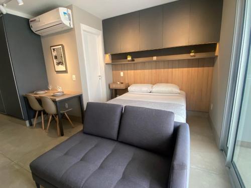 a bedroom with a bed and a couch and a table at Flat WiseSP - Expo Anhembi in Sao Paulo