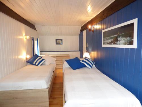 two beds in a room with blue walls at Domaine de Pratulo in Cléden-Poher