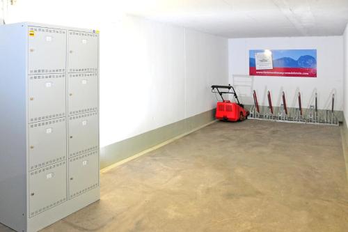 a room with lockers and a red mower in it at Ferienwohnungen Wendelstein in Bad Feilnbach