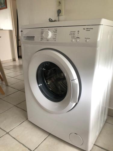 a white washing machine sitting in a kitchen at Appartement vue sur Mer in Plérin