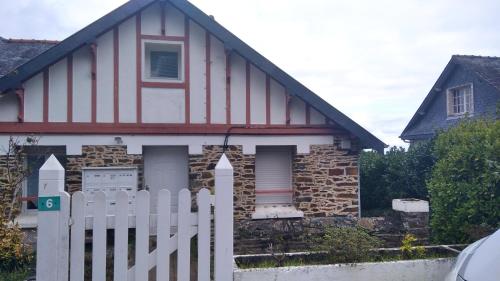 a red and white house with a white fence at Appartement vue sur Mer in Plérin