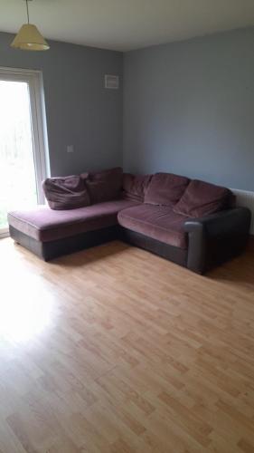 a couch in a living room with a wooden floor at Hawthorn Walk in Kilkenny