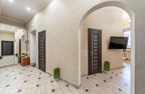 an arched hallway with two doors and a flat screen tv at Maidan, Khreschatyk 3BR in Kyiv