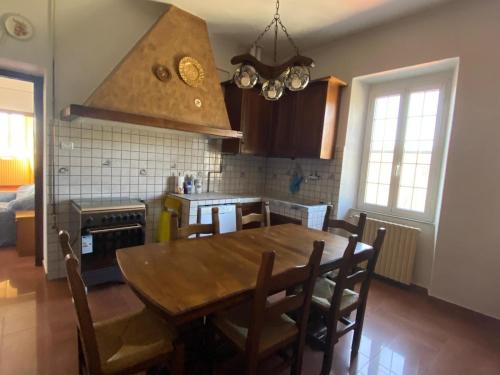 cocina con mesa de madera y comedor en Casa Vacanze Nonna Nella, en Villafranca in Lunigiana