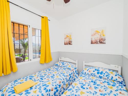 アラウリン・エル・グランデにあるCubo's Finca Rio de las Pasadasの黄色いカーテン付きのベッドルームのベッド2台