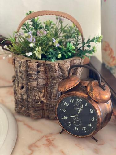 a clock sitting on a table next to a flower pot at Quinta Castanheiro da Penha - Alegrete - Portalegre - Alentejo in Alegrete