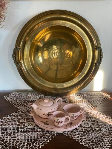 a gold plate with two cups and saucers on a table at Quinta Castanheiro da Penha - Alegrete - Portalegre - Alentejo in Alegrete