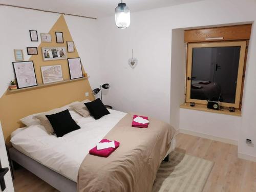 - une chambre avec un lit doté d'oreillers rouges dans l'établissement La Poissonnais, à Saint-Lormel