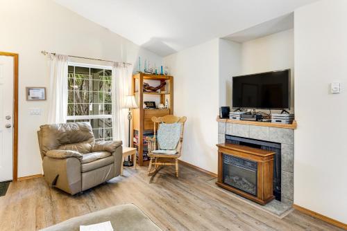 a living room with a chair and a fireplace at Cedar Creek Retreat in Rockaway Beach