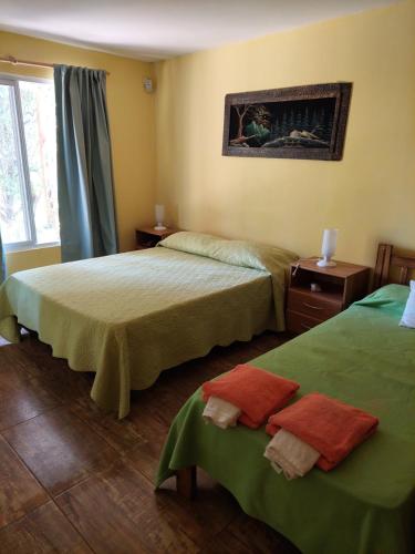 twee bedden in een hotelkamer met groene lakens bij CABAÑAS MAY . in San Rafael