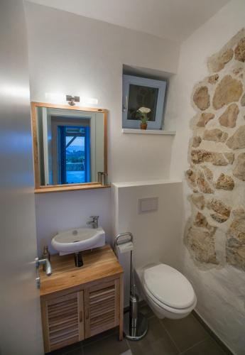 a bathroom with a sink and a toilet and a mirror at Villa Mora in Banjol
