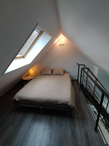 - une chambre mansardée avec une fenêtre dans l'établissement Le Charmant, à Bohain-en-Vermandois