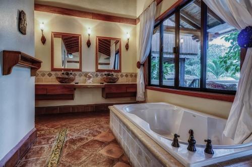 a large bathroom with a tub and a window at Almond Beach Resort at Jaguar Reef in Hopkins