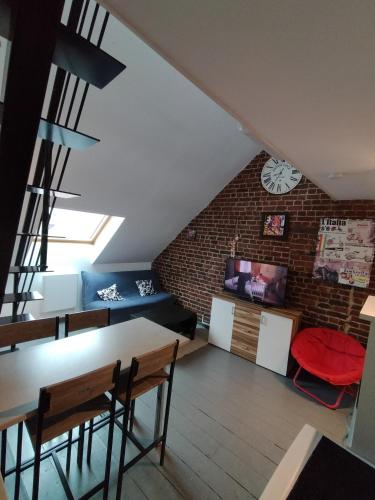 un salon avec un mur de briques dans l'établissement Le Charmant, à Bohain-en-Vermandois