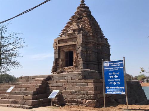 a small stone building with a sign in front of it at Friends in Khajuraho in Khajurāho