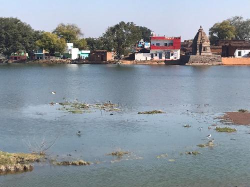 a view of a body of water with a temple at Friends in Khajuraho in Khajurāho