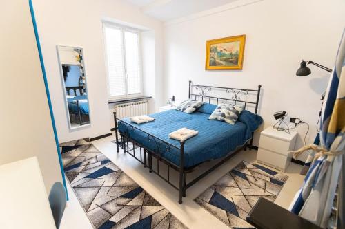 1 dormitorio con cama azul y espejo en Acquario 1' Free Wifi & Netflix ''Typical Italian House'' By TILO Apartment's, en Génova