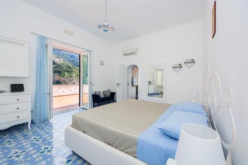 una camera da letto bianca con un letto e una finestra di YourHome - Lorena Maria House Positano a Positano