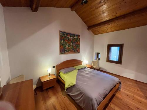 een slaapkamer met een bed en 2 tafels met lampen bij Mida & Lino' s House casa rustica in Solagna