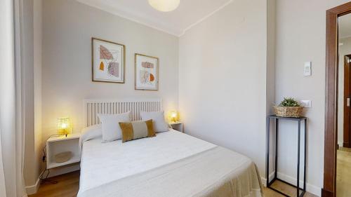 1 dormitorio blanco con 1 cama blanca y 2 lámparas en Porvenir Diseño Moderno, en Jerez de la Frontera