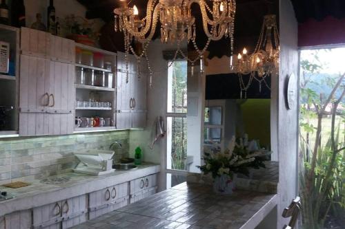 uma cozinha com armários brancos e uma grande janela em Suite Campestre Flamingo Paipa Boyaca em Paipa