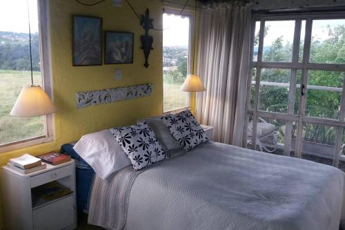ein Schlafzimmer mit einem Bett und einem großen Fenster in der Unterkunft Suite Campestre Flamingo Paipa Boyaca in Paipa