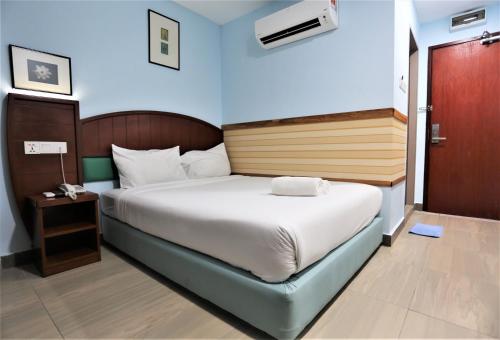 una camera con un grande letto con comodino e un letto sidx sidx. di ORKID Hills at Pudu a Kuala Lumpur