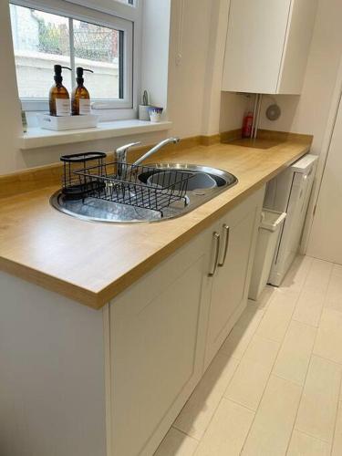 encimera de cocina con fregadero y ventana en Family Friendly House in Norwich with Parking en Norwich