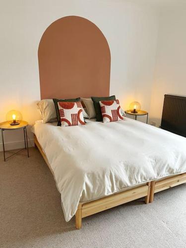 a bedroom with a large bed with two side tables at Family Friendly House in Norwich with Parking in Norwich