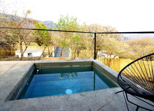 uma pequena piscina com uma mesa e uma cadeira em Piedra de Cobre em Tepoztlán