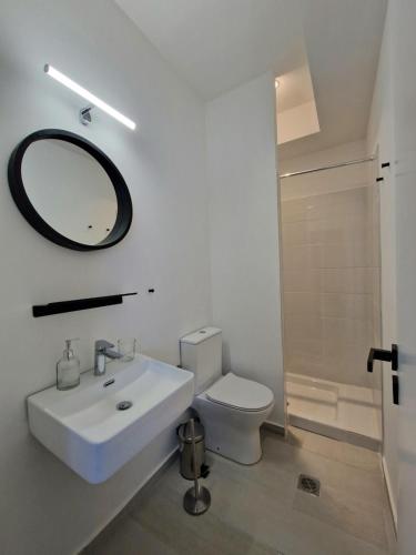 a white bathroom with a sink and a mirror at plefsea in Afitos