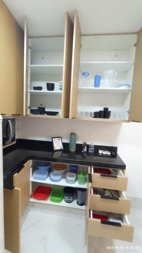 a kitchen with an open cabinet with food items at Casa com piscina e hidromassagem praia Enseada. in Guarujá