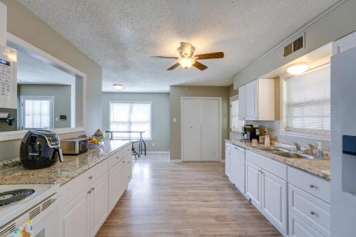 a large kitchen with white cabinets and a ceiling fan at Memphis Vacation Rental - Walk to Graceland! in Memphis