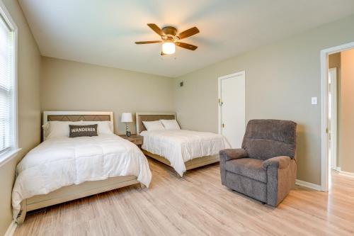 a bedroom with two beds and a chair and a ceiling fan at Memphis Vacation Rental - Walk to Graceland! in Memphis