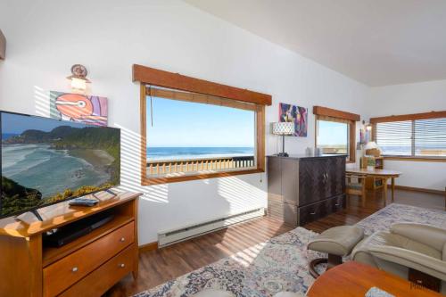 a living room with a tv and a large window at Pacific Lookout in Florence