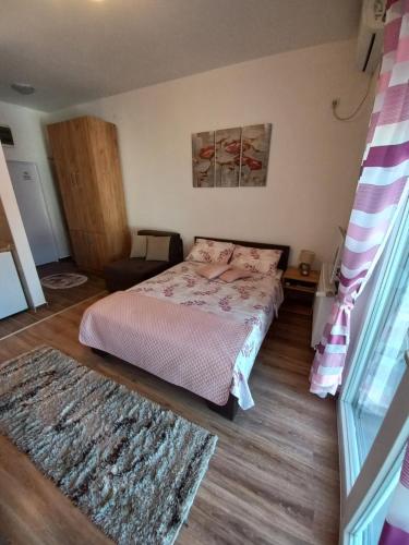 バニャ・コヴィリャチャにあるApartman Mokaのベッドとラグ付きの小さなベッドルーム1室が備わります。