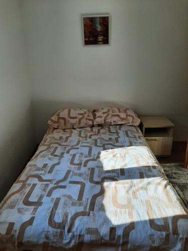 a bed with a quilt on it in a bedroom at Apartman „Škobić” in Višegrad