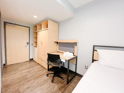 a small room with a desk and a bed at Queen's University Residence in Kingston